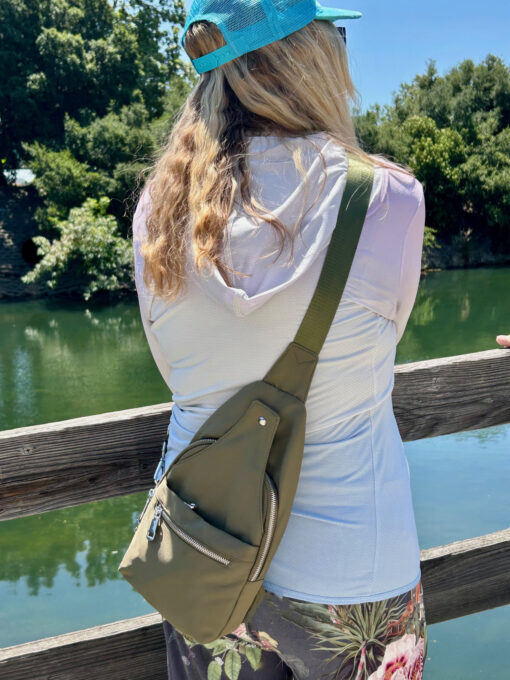 Woman wearing Stringfield Sling bag in pine color.